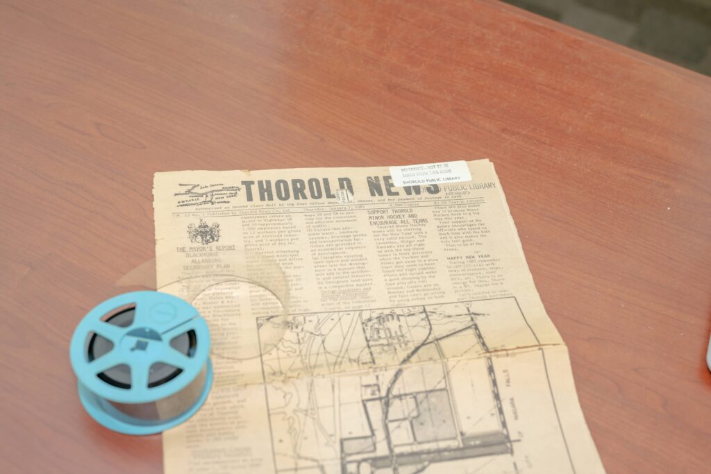 Microform reel alongside a physical copy of the Thorold News