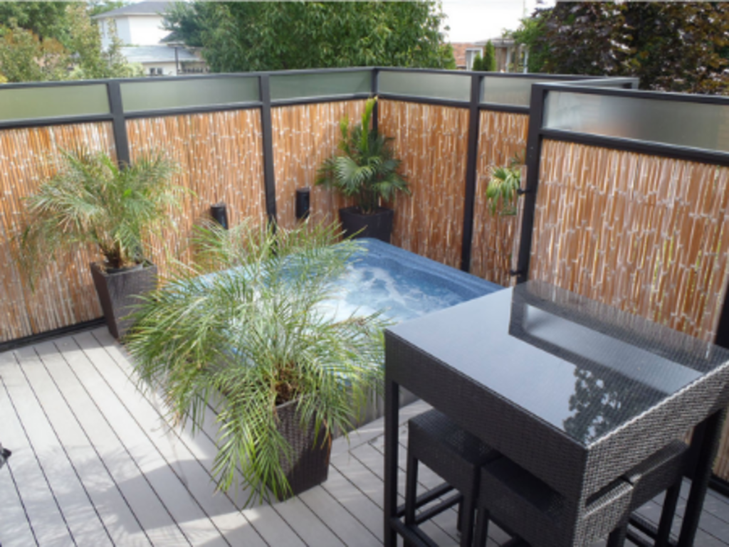 Spa on deck with greenery and privacy fencing