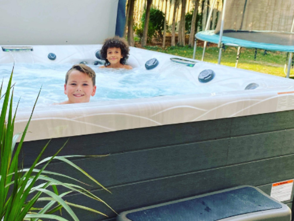 Young children sitting in an outdoor spa