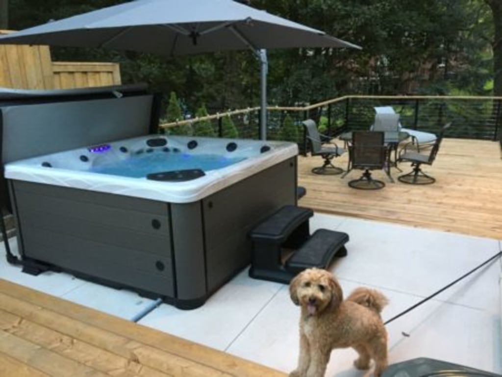 Deck with spa, seating area and a dog